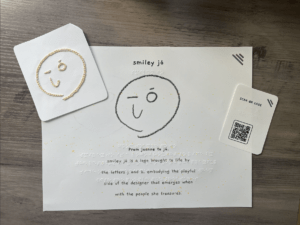 Final tactile pieces, including embroidered smiley jó logo, pamphlet, and QR code